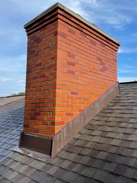 Tall brick chimney corner detail against blue sky